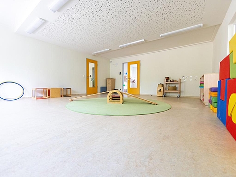 Ein Bewegungsraum mit viel freiem Platz und Sportausstattung wie Hula-Hoop-Reifen